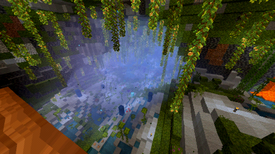 A screenshot of the game Minecraft. The screenshot shows a large lush cave biome. The screenshot is taken with a PlayStation 1-style shader, which results in the cave being filled with fog. The screenshot is taken from a vantage point, and below small pools of water and decorative pillars of minerals can be seen. The cave is illuminated by glow berries hanging from the ceiling, torches dotted around, and a nearby cascade of lava.